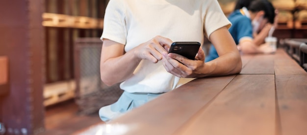 Casual zakenvrouw die smartphone vasthoudt en gebruikt voor sms-berichten jonge vrouw touchscreen mobiele telefoon typt in café of moderne kantoorlevensstijltechnologie Sociale media en netwerkconcept