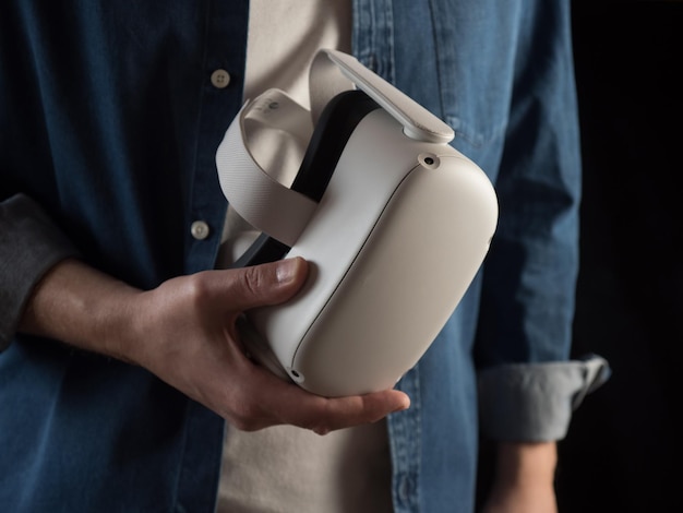 Casually dressed man holding a virtual reality headset