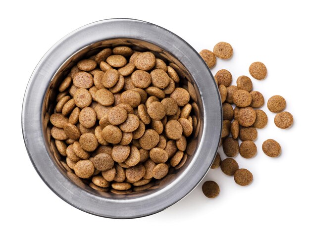 Photo cat food in a bowl and spilled closeup on a white background top view