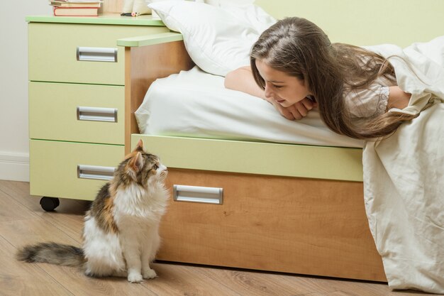 Cat zit in de buurt van het bed met een baby