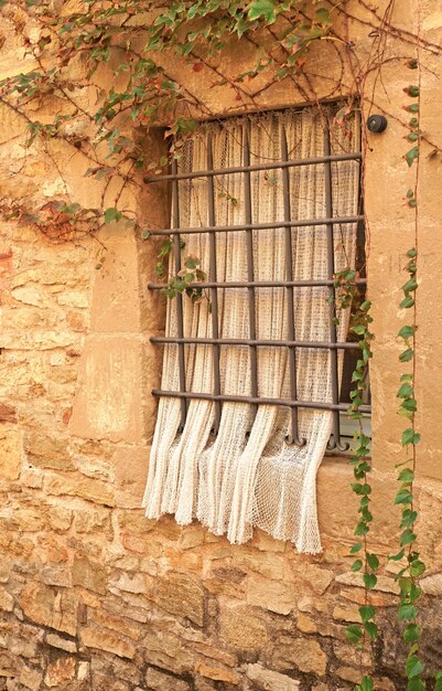 Photo catalonia old village in spain charming old streets typical village with beautiful stone houses curtain on the window of an old house