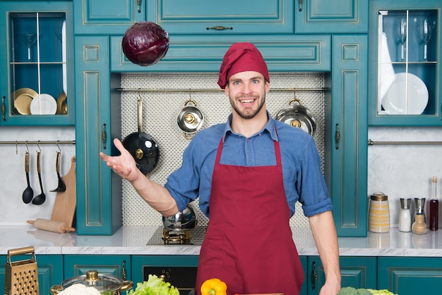 Catch it Handsome cook in kitchen Chef following recipe Cooking dinner with traditional recipe Preparing meal Healthy food Professional kitchen Traditional cuisine Man at kitchen concept