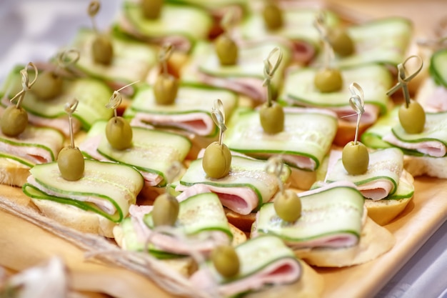Catering of canape with olives, cucumber and ham