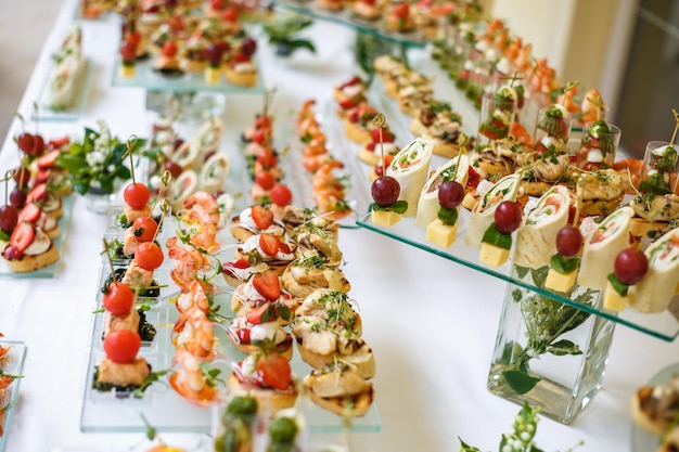 Catering offsite food buffet table with various canapes\
sandwiches hamburgers and snacks