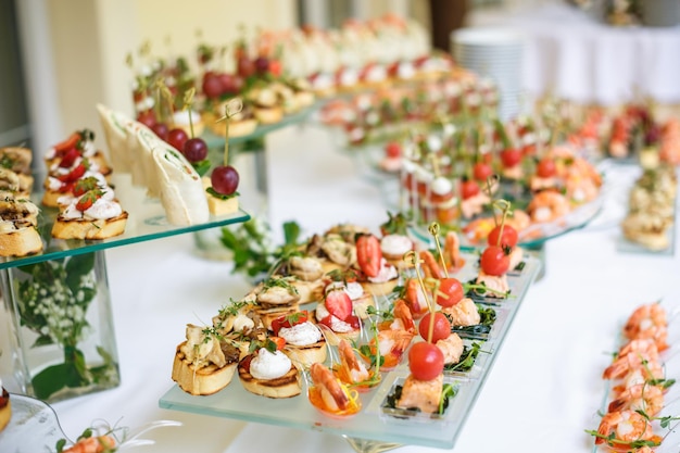 Catering offsite food buffet table with various canapes\
sandwiches hamburgers and snacks