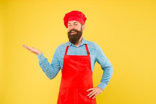 Catering voor u welkom in ons café tijd voor lunch vrolijke bebaarde chef-kok brutale mannelijke kok in hoed en schort professionele man koken restaurant keuken en culinaire catering bedrijf bedrijf