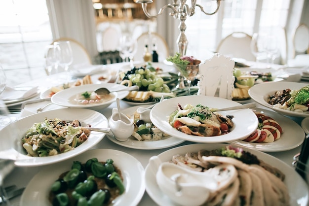 Cateringservicetafel met eten en drinken in restaurant voor huwelijksfeestx9