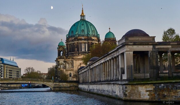 Photo cathedral by river against sky in city