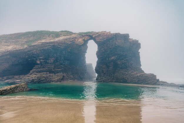 Photo cathedrals beach in galicia spainn foggy landscape with playa de las catedrales catedrais beach in