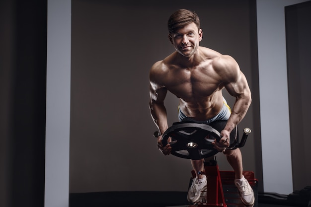 Caucasian athletic man exercising pumping up muscles. strong
bodybuilder with six pack, perfect abs. fitness and sport
concept