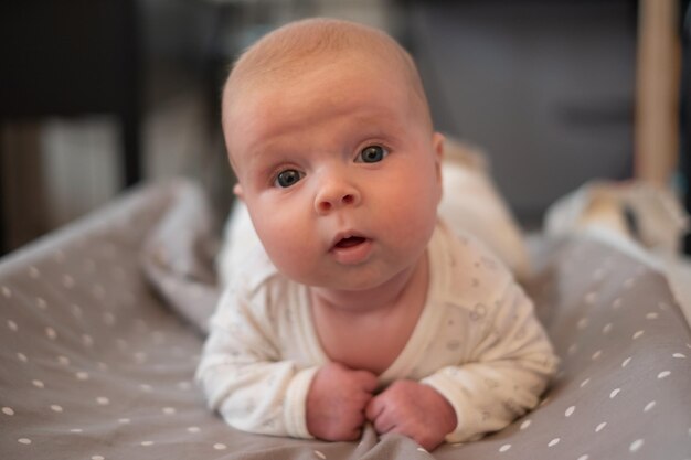 Caucasian baby study to hold head lying on belly