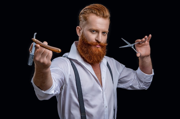 caucasian barber man in studio barber man with scissors and retro razor blade photo of barber man on background barber man isolated in black