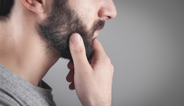 Caucasian bearded man in grey background.