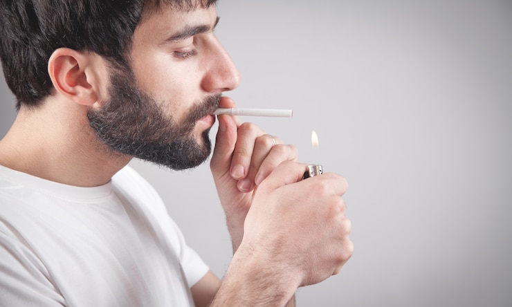 Photo caucasian bearded man smoking cigarette in office.