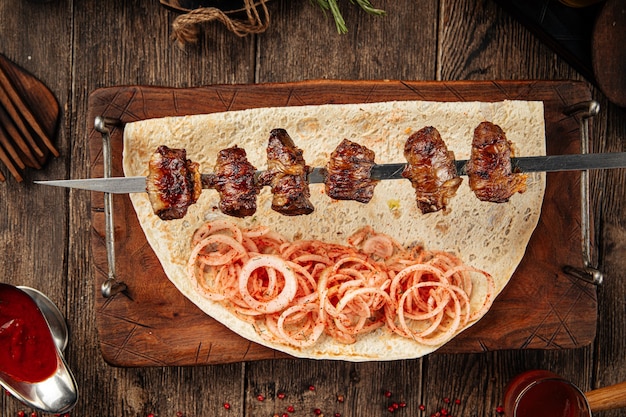 Photo caucasian beef liver in the shell shashlik skewers