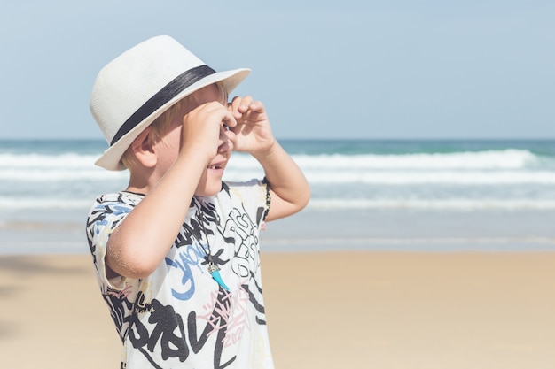 Кавказский мальчик из Европы со счастливым и расслабленным временем на тропическом пляже