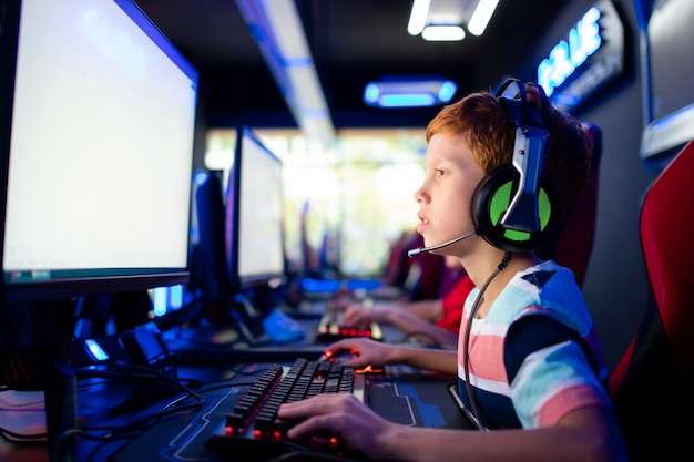 Caucasian boy gamer playing video games with friends on\
computer in game room