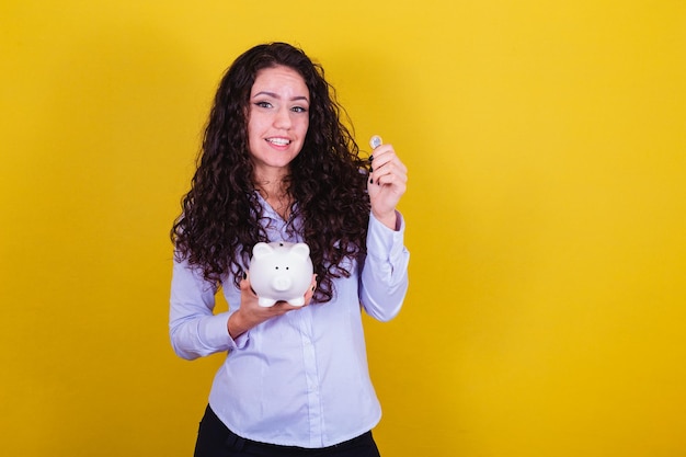 Caucasian brazilian woman holding coin and piggy bank concept
of finance economy saving