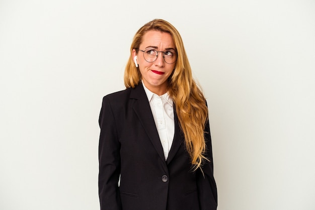 Caucasian business woman wearing a wireless headphones isolated on white background confused, feels doubtful and unsure.