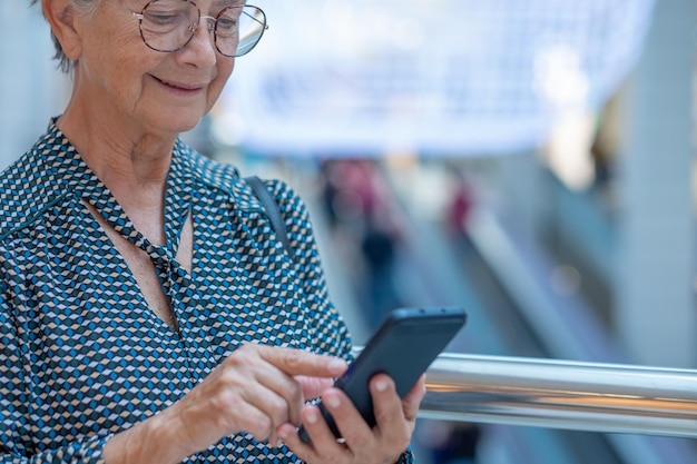Caucasian business woman with eyeglasses using mobile phone indoors