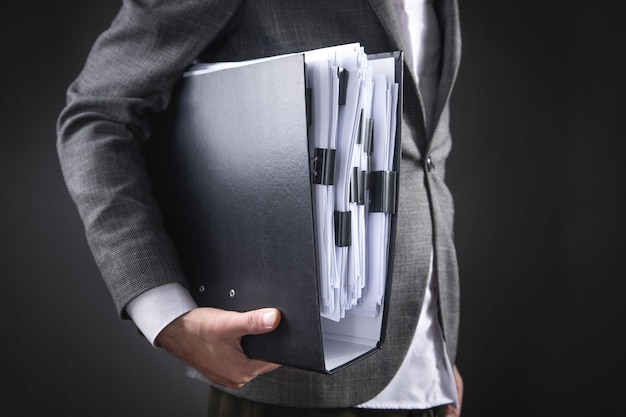 Caucasian businessman holding documents in office.