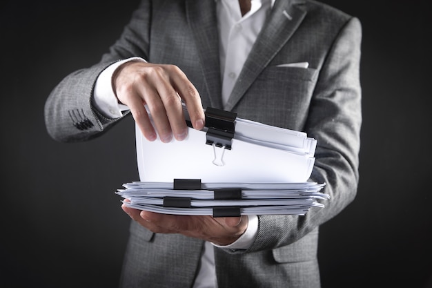 Caucasian businessman holding documents in office.