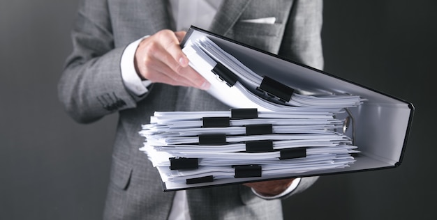 Caucasian businessman holding documents in office.