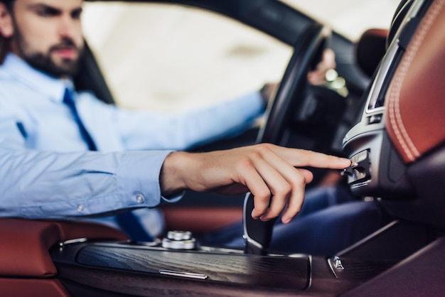 Caucasian businessman pushing button on the dashboard in the car