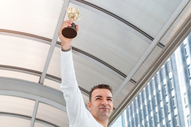 Foto l'uomo d'affari caucasico vince un trofeo.