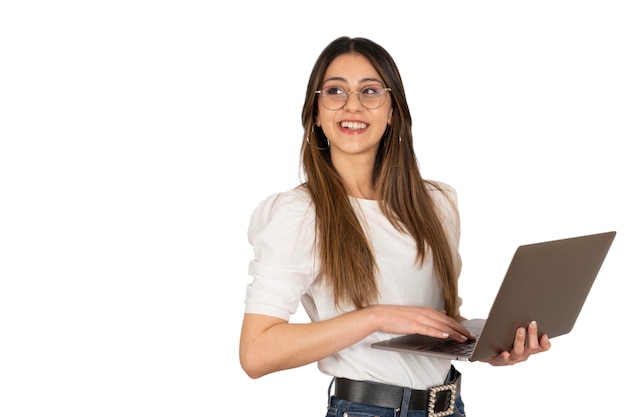 Foto imprenditrice caucasica tenendo il computer portatile in piedi su sfondo bianco isolato guardando lo spazio della copia