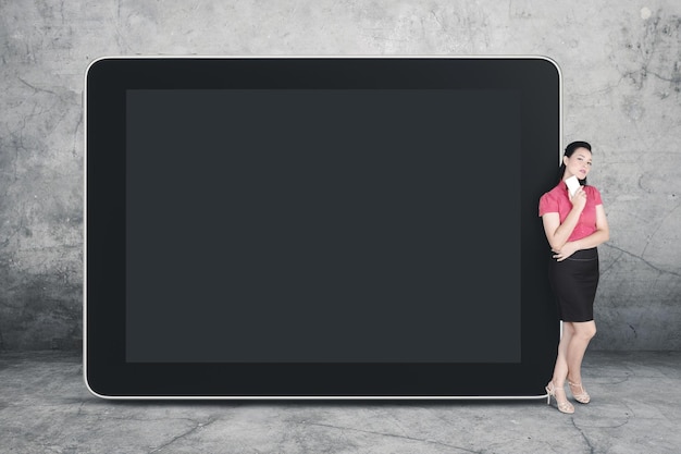 Caucasian businesswoman leaning on a blank tablet