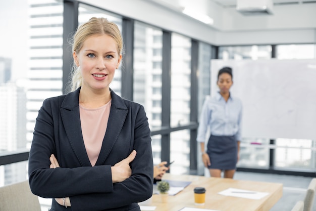 Caucasian businesswoman looking at camera in meeting room.