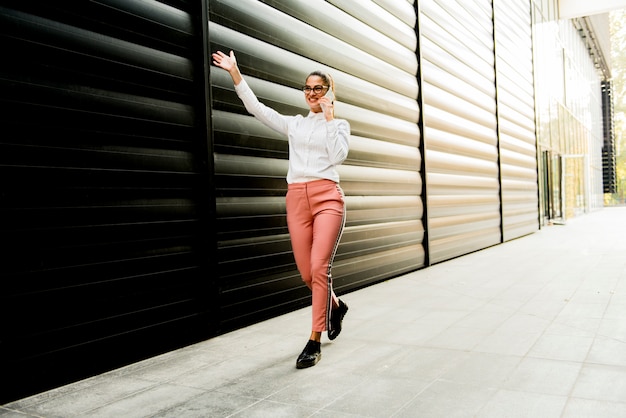 Caucasian businesswoman using smartphone outdoor