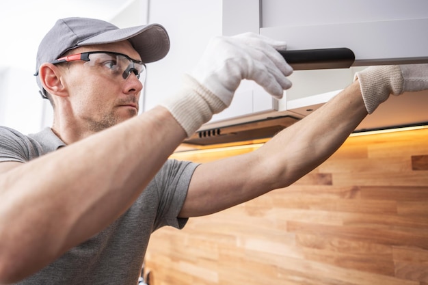 Photo caucasian cabinetmaker assembling kitchen cabinets