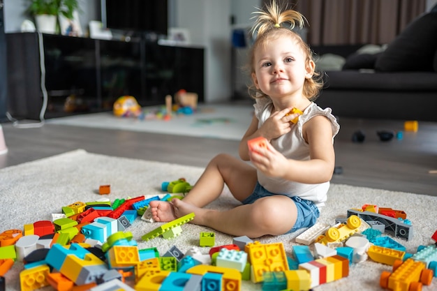 Caucasian child a little girl is playing in the constructor at home educational toys for children