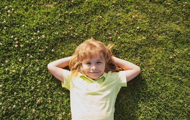 Caucasian child lying on grass Kids enjoying summer