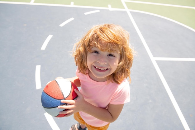 Caucasian child play basketball portrait. Kids face.