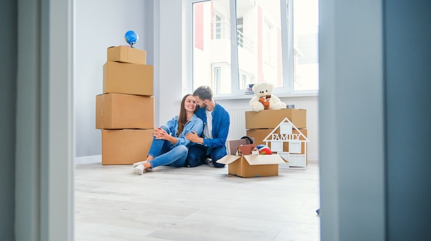 Caucasian couple moving in new home. Young stylish couple in moving in mess.