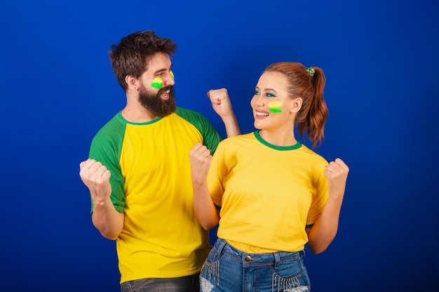 Caucasian couple soccer fans from Brazil celebrating and cheering