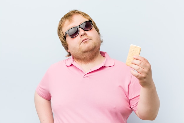 Caucasian crazy blond fat man holding an ice cream