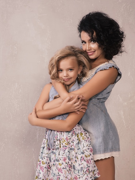 Caucasian cute mother hugging daughter