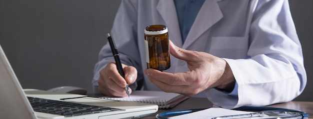 Caucasian doctor holding bottle of pills