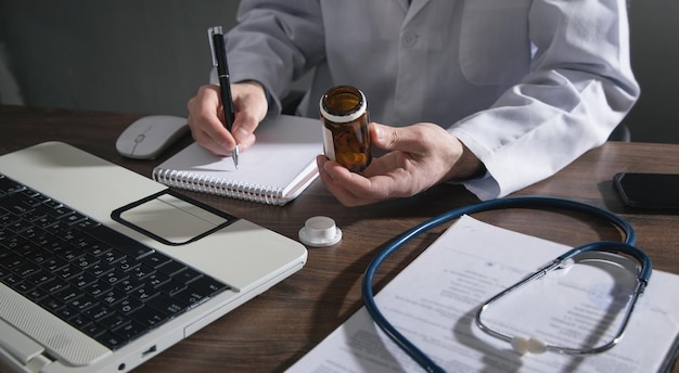 Caucasian doctor holding bottle of pills.