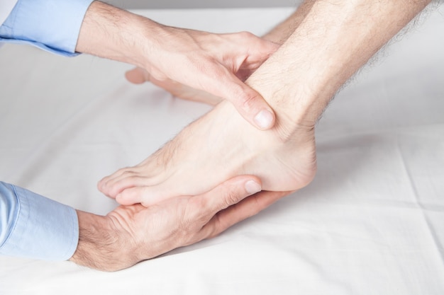 Caucasian doctor massaging patient foot