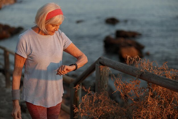 Caucasian elderly woman at daily fitness regime outdoors