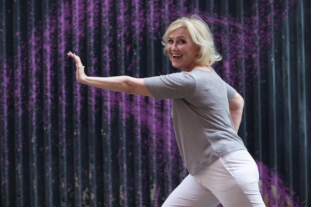 Caucasian elderly woman doing qigong exercise summer outdoor