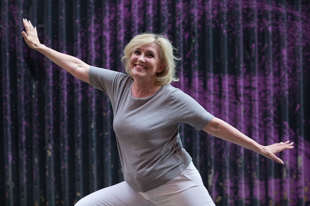 Caucasian elderly woman doing qigong exercise summer outdoor