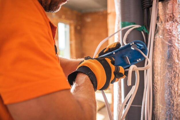 Caucasian electrician in his 40s preparing electric outlet inside concrete bricks commercial building construction industry theme