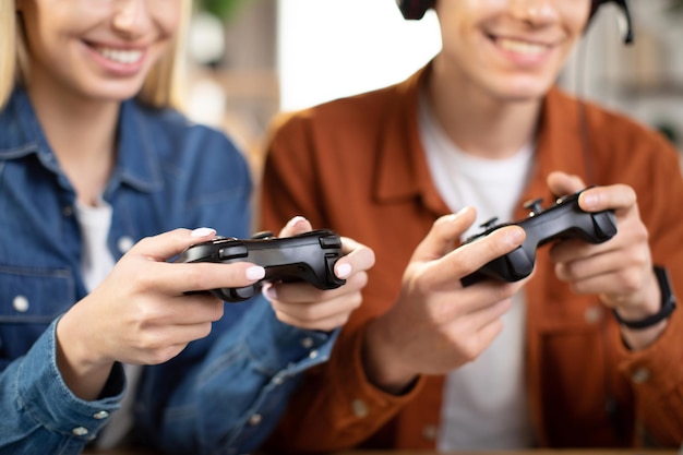 Caucasian family hands holding joysticks and enjoying their free time playing new games at home