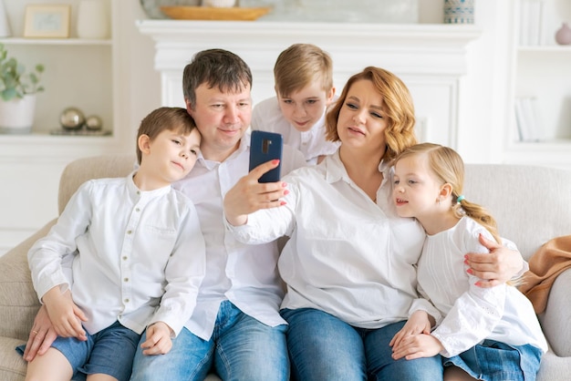 Кавказская семья сидит на диване в гостиной дома Мать отец маленький
